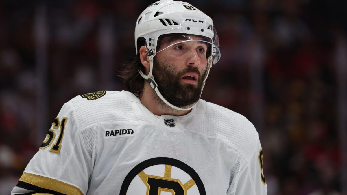 Pat Maroon delivers a powerful hit to a Bruins player, sending him into the bench.