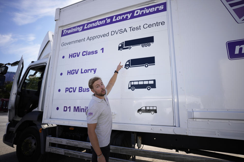 Laurence Bolton, the Managing Director of the National Driving Centre, points out different truck and vehicle categories at the National Driving Centre in Croydon, south London, Wednesday, Sept. 22, 2021. Britain doesn't have enough truck drivers. The shortage is contributing to scarcity of everything from McDonald's milkshakes to supermarket produce. (AP Photo/Matt Dunham)