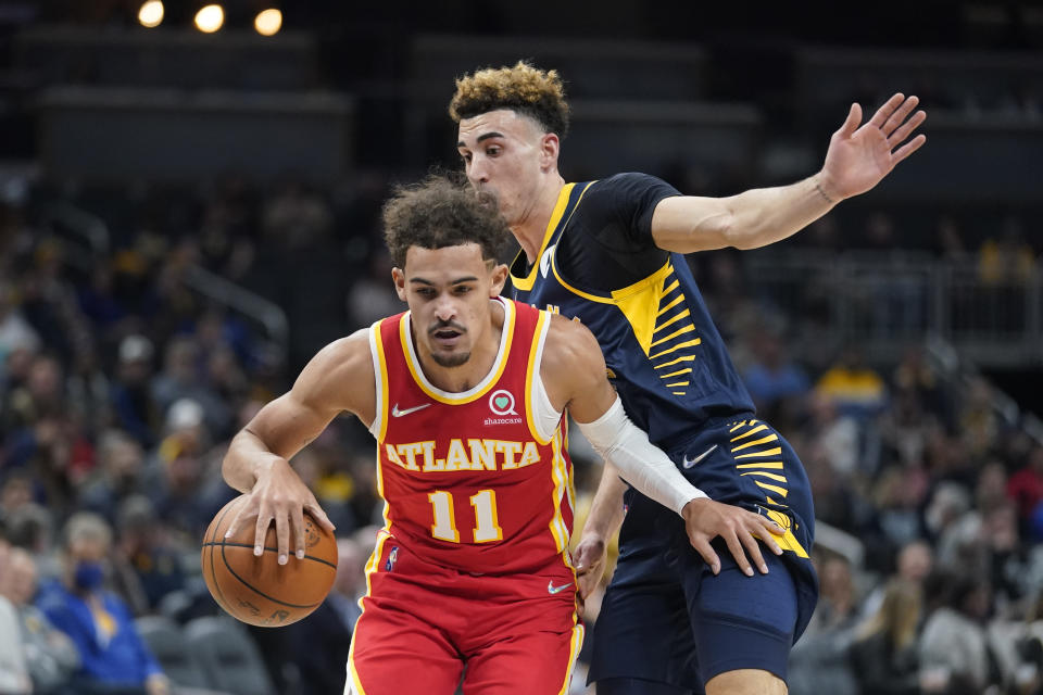 Atlanta Hawks' Trae Young (11) is defended by Indiana Pacers' Chris Duarte during the first half of an NBA basketball game Wednesday, Dec. 1, 2021, in Indianapolis. (AP Photo/Darron Cummings)