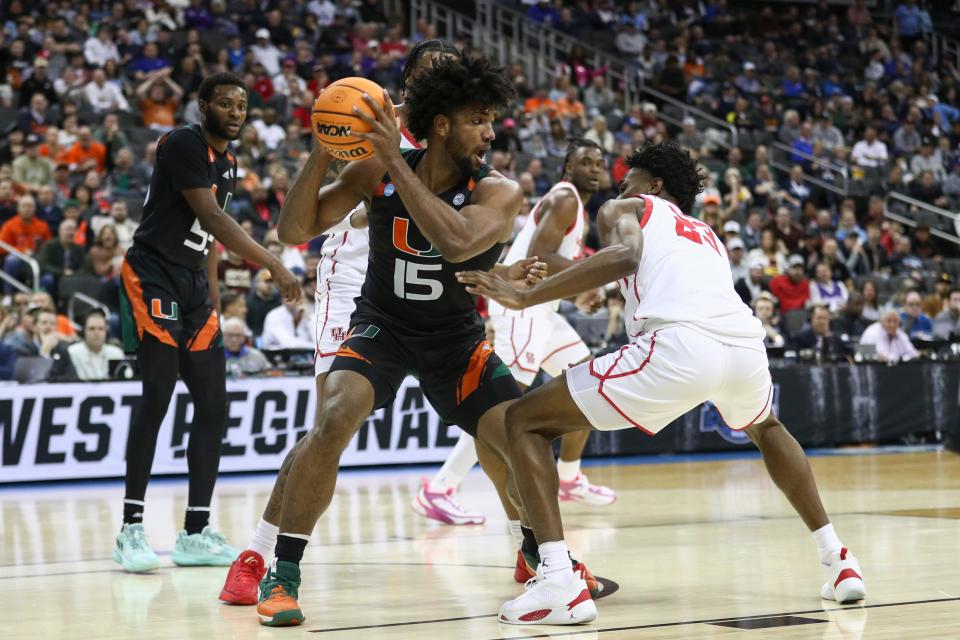 Miami (Fla.) forward Norchad Omier (15) is defended by Houston guard Terrance Arceneaux (23) defends during  their NCAA tournament game at T-Mobile Center.