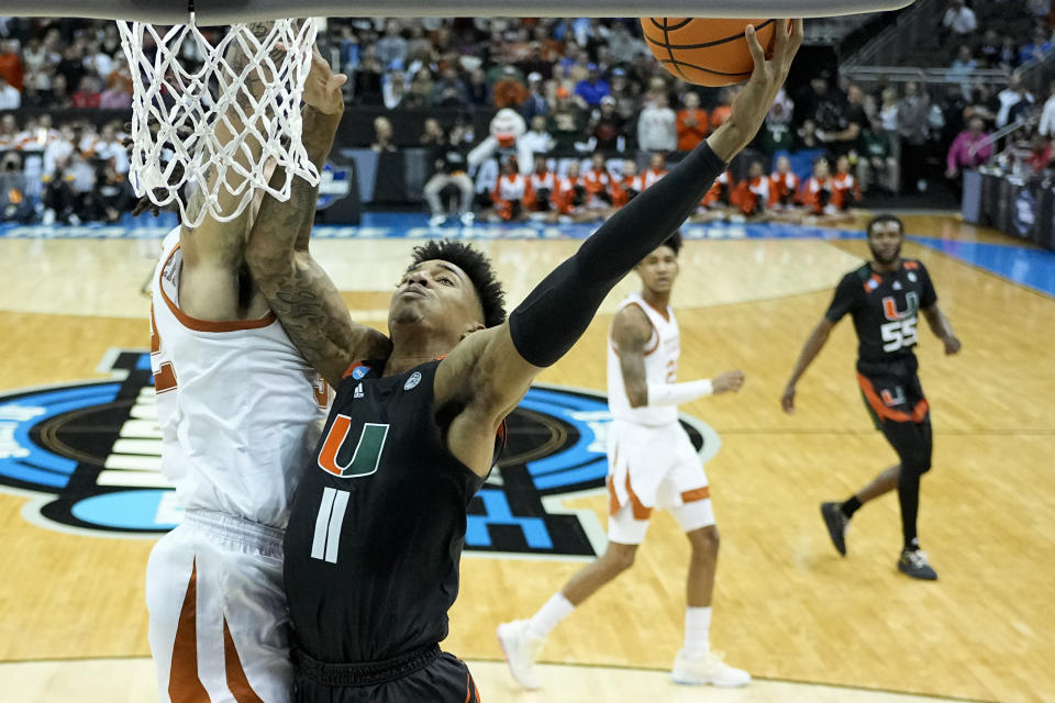 Miami forward Anthony Walker shoots over Texas forward Christian Bishop in the first half of an Elite 8 college basketball game in the Midwest Regional of the NCAA Tournament Sunday, March 26, 2023, in Kansas City, Mo. (AP Photo/Jeff Roberson)