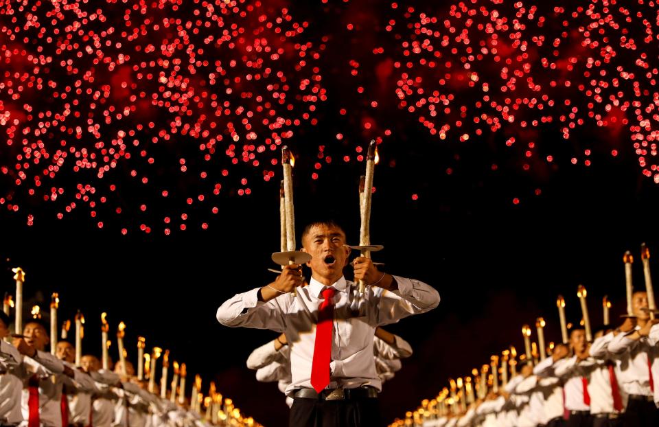 ireworks explode over participants carrying torches during a torchlight procession during the celebration marking the 70th anniversary of North Korea's foundation in Pyongyang, North Korea, September 10, 2018.