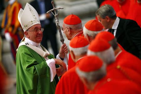 Pope Francis greets a cardinal as he leaves at the end of a mass to mark the opening of the synod on the family in Saint Peter's Square at the Vatican October 5, 2014. REUTERS/Tony Gentile