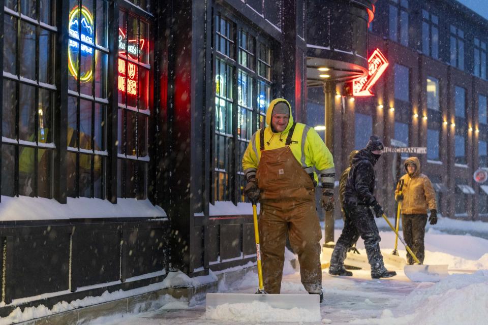 Workers shovel sidewalks in Ankeny, Iowa, Friday, Jan. 12, 2024. (AP Photo/Andrew Harnik)
