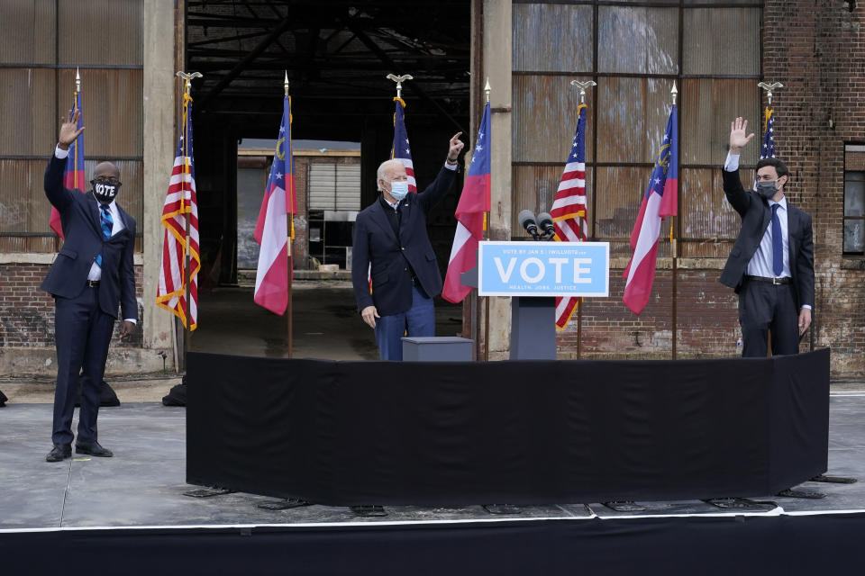 FILE - In this Dec. 15, 2020, file photo President-elect Joe Biden, center, acknowledge supporters at the end of a drive-in rally for Georgia Democratic candidates for U.S. Senate Raphael Warnock, left, and Jon Ossoff in Atlanta. (AP Photo/Patrick Semansky, File)