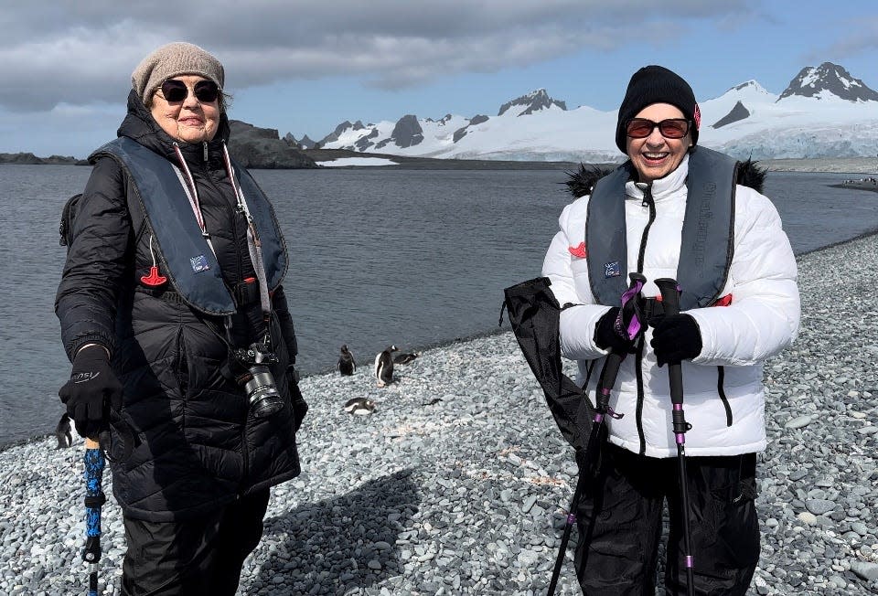 Best friends Ellie Hamby and Sandy Hazelip pose with penguins in Antarctica in January.