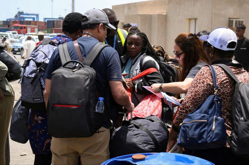 FILE PHOTO: European, Asian and African nationals prepare to board a ship to Saudi Arabia, at Port Sudan