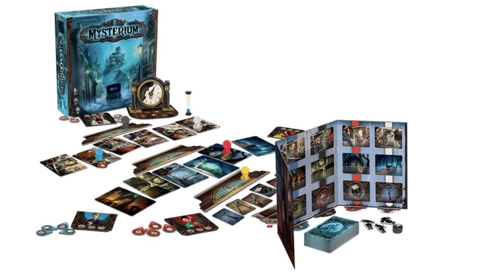 Mysterium the bosrd game with the box behind the game set up on a table