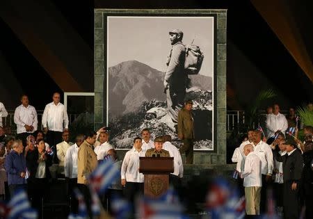 Cuban President Raul Castro speaks at a tribute to his brother and late former Cuban leader Fidel Castro (shown in image on wall) in Santiago de Cuba, Cuba, December 3, 2016. REUTERS/Carlos Garcia Rawlins