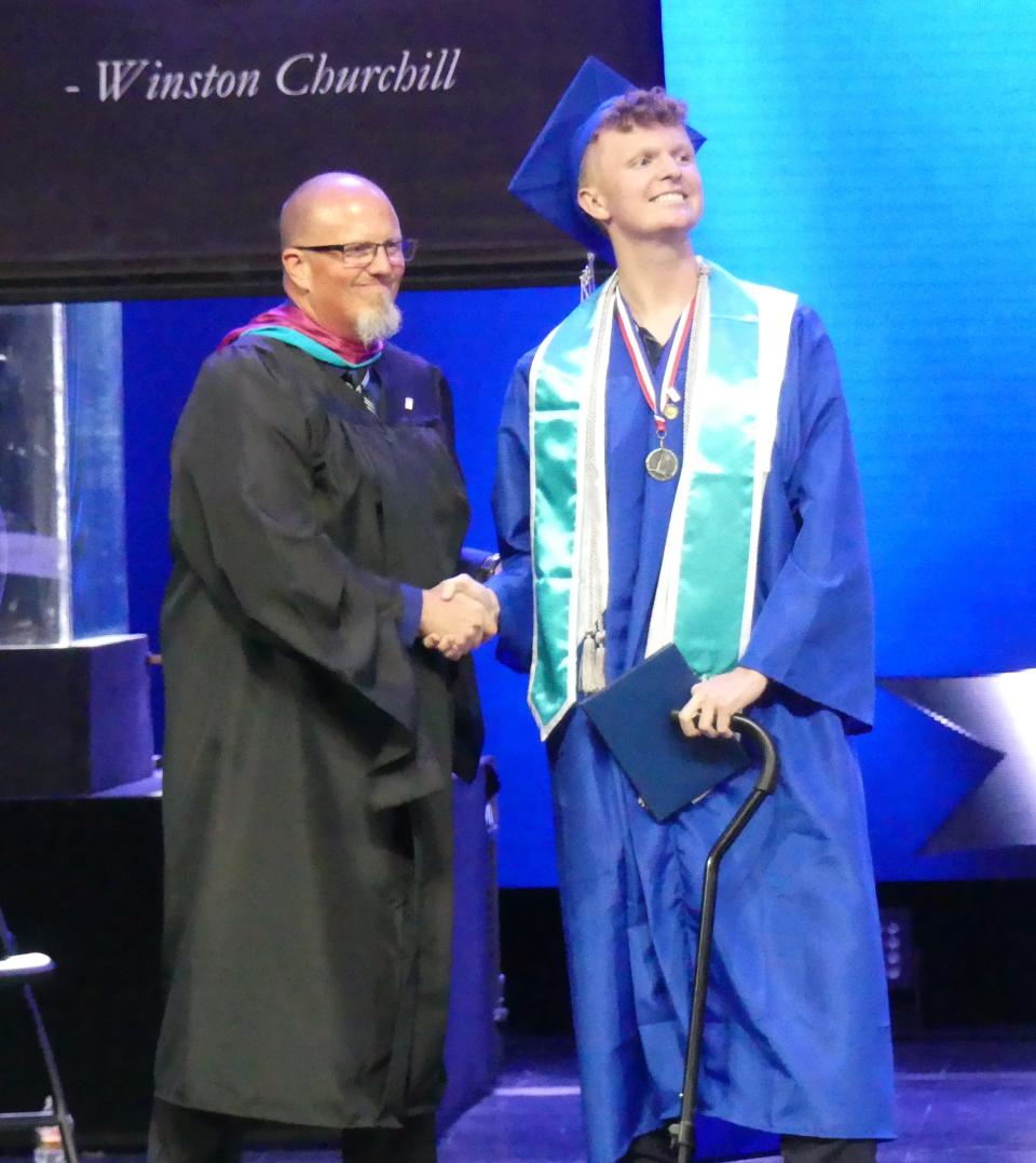 Principal Chet Richards congratulates senior and cancer fighter Alex Alan Parraga during the Academy for Academic Excellence annual commencement ceremony on Friday, June 9, 2023 at High Desert Church in Victorville.