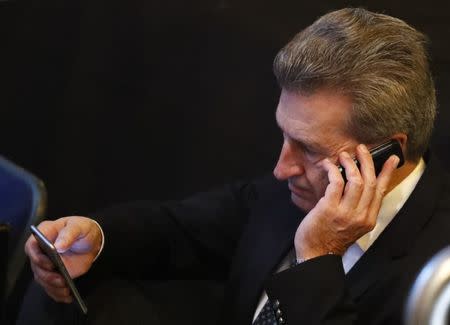 Gunther Oettinger, European Commissioner of Digital Science and Society uses mobile phones during the conservative Christian Democratic Union CDU party convention in Essen, Germany, December 6, 2016. REUTERS/Wolfgang Rattay