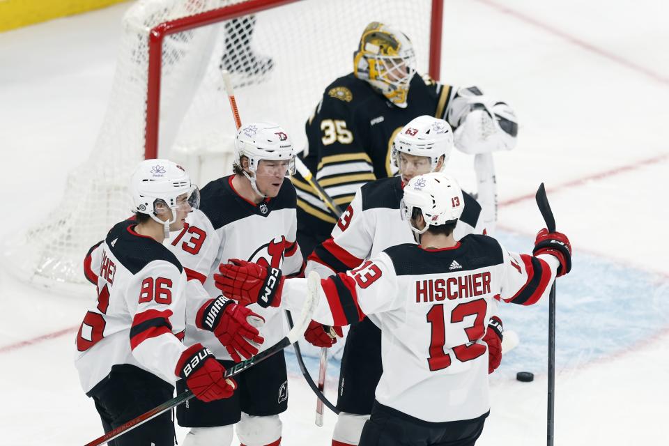New Jersey Devils' Nico Hischier (13) celebrates his goal on Boston Bruins' Linus Ullmark (35) with Jack Hughes (86), Tyler Toffoli (73) and Jesper Bratt (63) during the first period of an NHL hockey game, Saturday, Dec. 30, 2023, in Boston. (AP Photo/Michael Dwyer)