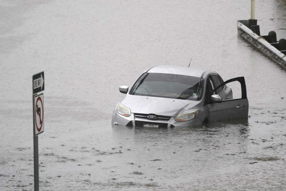 A car sits in flood waters covering a closed highway in Dallas, Monday, Aug. 22, 2022. (AP Photo/LM Otero)