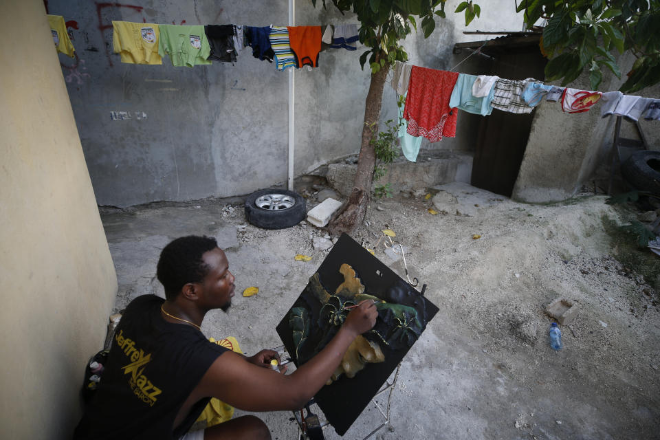 Entrepreneur and youth leader Pascéus Juvensky St. Fleur, 26, works on a multimedia painting in the courtyard of his family's home in the Delmas neighborhood of Port-au-Prince, Haiti, Tuesday, Oct. 8, 2019. St. Fleur says the protests are not only about replacing a president, but changing a system. "It's not one person, it's not one regime, it's not a president, it's not the opposition, it's not the bourgeoisie, but it's us who should do it," he said. "We dream of, and we want, a better Haiti."(AP Photo/Rebecca Blackwell)