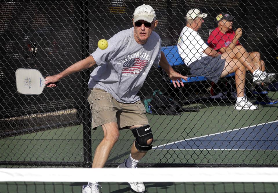 Hybride de tennis, de badminton et de tennis de table, le pickleball se joue sur un terrain d'un quart de la taille d'un court de tennis.  (AP Photo/Matt York)