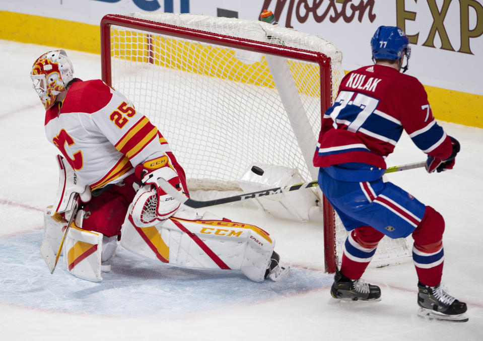 Montreal Canadiens' Brett Kulak (77) scores on Calgary Flames goaltender Jacob Markstrom (25) during the second period of an NHL hockey game Wednesday, April 14, 2021 in Montreal. (Ryan Remiorz/Canadian Press via AP)