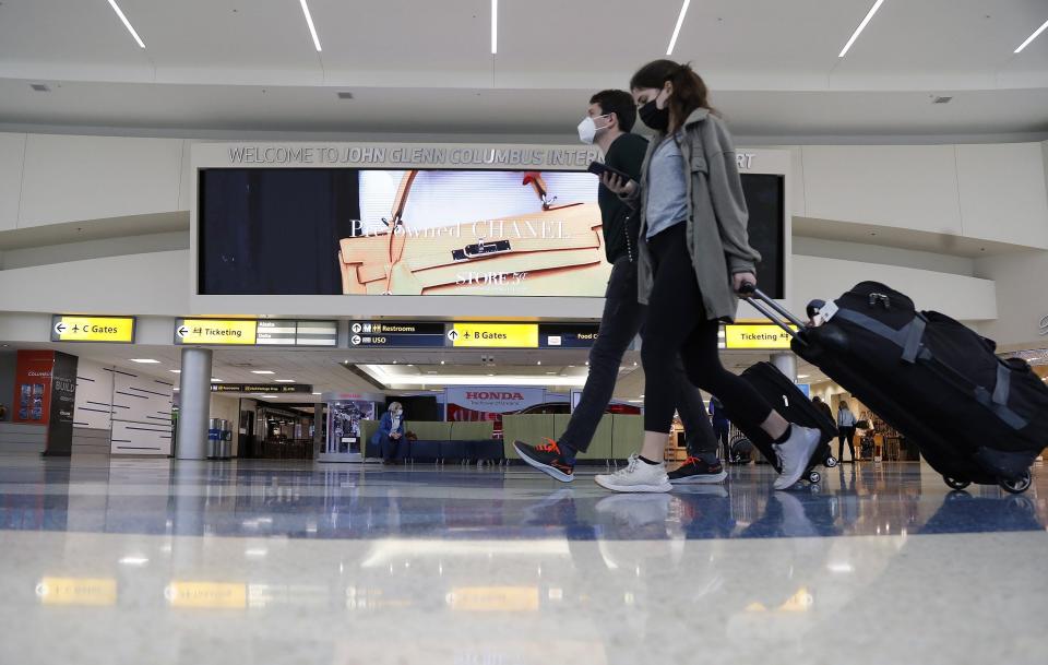 Travelers walk through John Glenn Columbus International Airport on Nov. 23, 2021. Holiday travel is expected to be heavier this year.