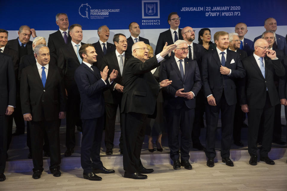 Líderes mundiales intentan organizarse para una foto de grupo tras una cena oficial, mientras el presidente de Israel, Reuven Rivlin (centro), da las gracias al cocinero de su residencia oficial, en Jerusalén, el 22 de enero de 2020. (Heidi Levine/Pool photo via AP)