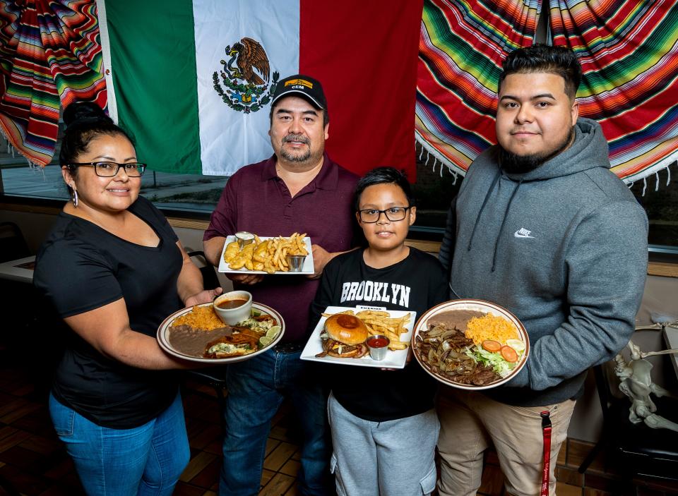 Kalibres Restaurant & Bar owner Alejandro Hernandez, right, poses with his 8-year-old son Alejandro Hernandez Jr., and his parents Agustin Hernandez and Nelda Hernandez on Oct. 21, 2023 at their restaurant in Milwaukee.