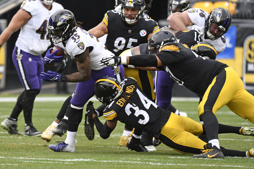 Baltimore Ravens running back Gus Edwards (35) is tackled by Pittsburgh Steelers safety Terrell Edmunds (34) during the first half of an NFL football game in Pittsburgh, Sunday, Dec. 11, 2022. (AP Photo/Don Wright)