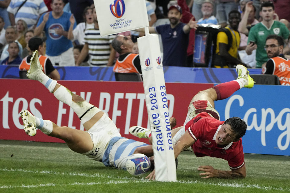 Argentina's Matias Moroni, left, tackles Wales' Louis Rees-Zammit and preventing from scoring during the Rugby World Cup quarterfinal match between Wales and Argentina at the Stade Vélodrome, in Marseille, France, Saturday, Oct. 14, 2023. (AP Photo/Laurent Cipriani)