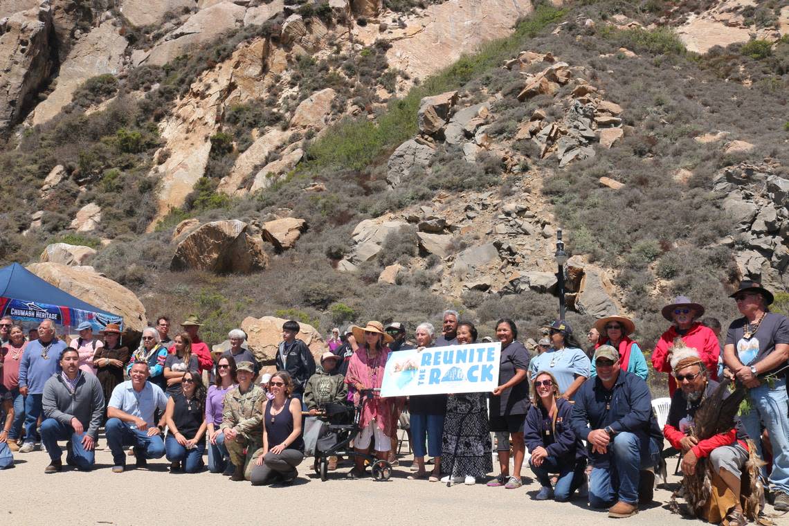 People pose for a picture in a ceremony celebrating the “reunification” of Morro Rock on Aug. 20, 2022.