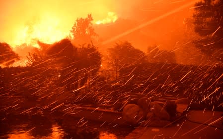 Flying embers fill the night sky to the ground from a wind-driven wildfire called the Saddle Ridge fire in the early morning hours Friday in Porter Ranch