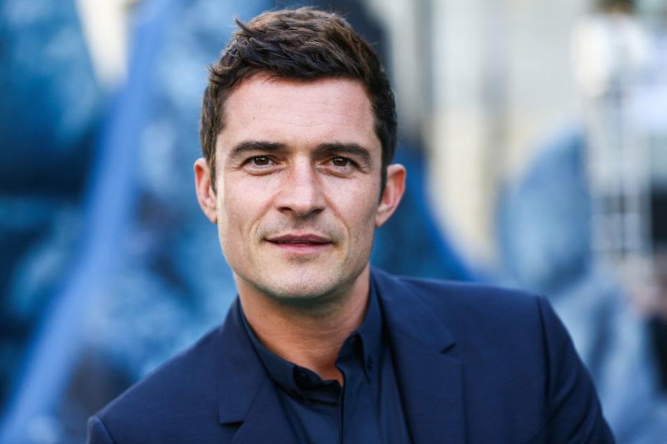 Orlando Bloom wears a dark blue suit