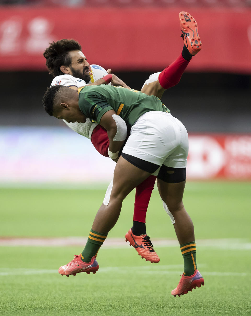 Spain's Pol Pla, back, is hit by South Africa's Angelo Davids during an HSBC Canada Sevens rugby game in Vancouver, British Columbia, Saturday, Sept. 18, 2021. (Darryl Dyck/The Canadian Press via AP)