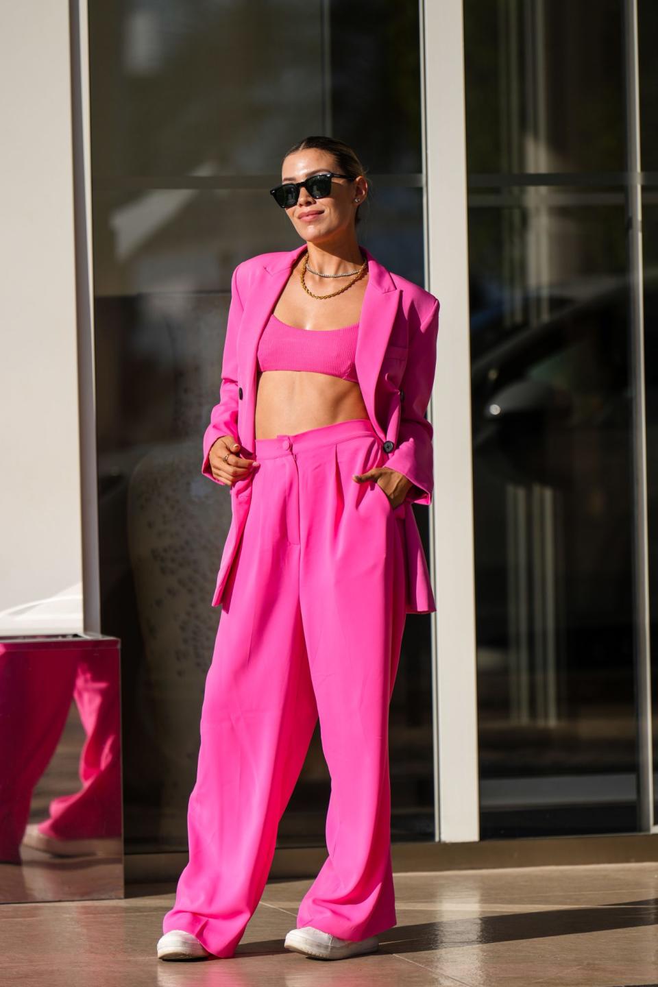 <p>Quedamos fascinadas con este conjunto rosado, de pantalón, chaqueta y crop top, que lució la socialité en Cannes. </p>