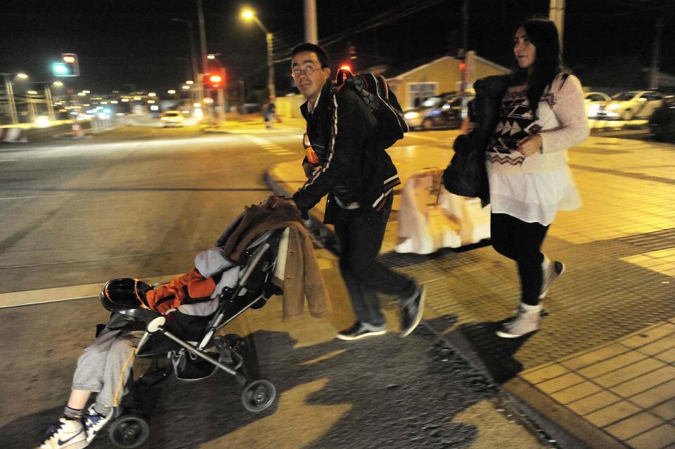 Residents walk to higher ground after a Tsunami alarm at Talcahuano city, south of Santiago on the southern Pacific coast, April 1, 2014. (REUTERS/Jose Luis Saavedra)