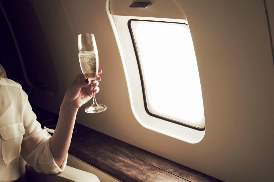 Businesswoman relaxing aboard private jet. (Flashpop / Getty Images)