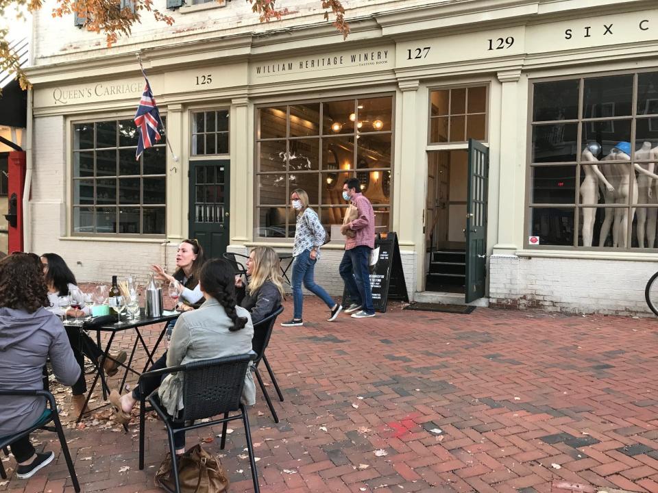 Some customers of William Heritage Winery tasting room on KIngs Highway in quaint Haddonfield sip wine outdoors during late fall while others drink inside or buy wine to go.