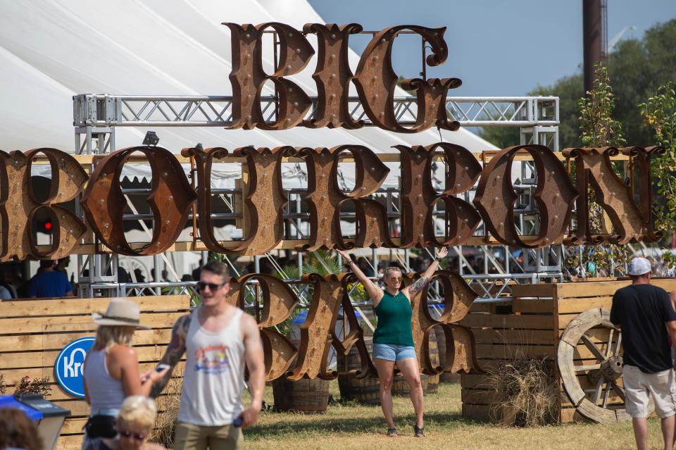 Attendants pose with bourbon signage during the first day of Bourbon and Beyond at the Highland Festival Grounds. Sept. 20, 2019