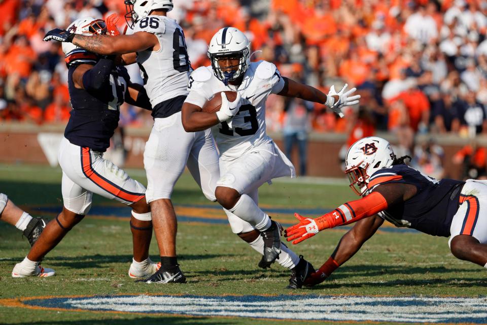 Penn State running back Kaytron Allen (13) avoids a tackle by Auburn defenders during their game in 2022 at Jordan-Hare Stadium.