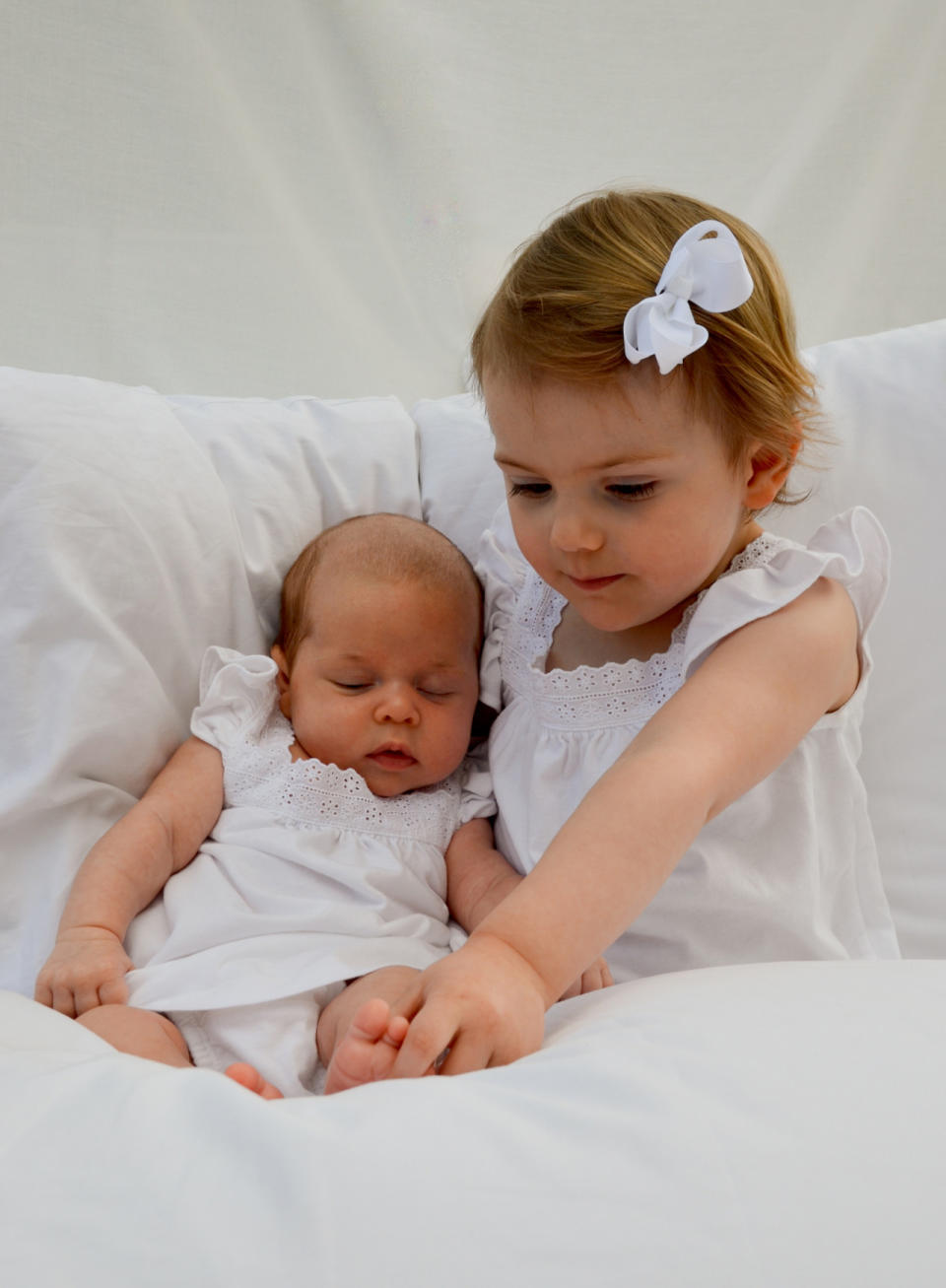 Dieses Foto von Estelle und ihrer frischgeborenen Cousine Leonore hat Kronprinzessin Victoria selbst geschossen. Die Mini-Prinzessinnen sehen sich zum ersten Mal. Zumindest Estelle, die neugierig die kleinen Füßchen untersucht, ob auch alle Zehen da sind. Leonore, das erste Kind von Prinzessin Madeleine, bekommt gar nichts mit, sie schläft in aller Ruhe.