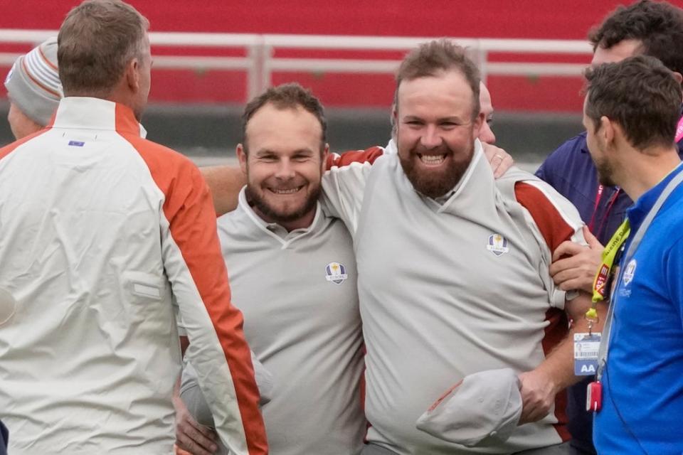 Shane Lowry and Tyrrell Hatton celebrate on the 18th hole after winning their four-ball match on day two of the Ryder Cup (Charlie Neibergall/AP) (AP)