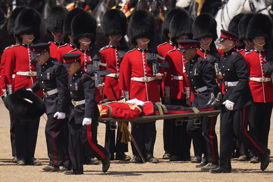 A soldier is carried out on a stretcher after a faint during the Colonel's Review, the final rehearsal of the Trooping the Colour, the King's annual birthday parade, at Horse Guards Parade in London, Saturday, June 10, 2023. (AP Photo/Alberto Pezzali)