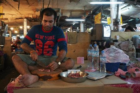 A vendor cuts meat at Vientiane's Thong Kan Kham market October 29, 2013. REUTERS/Aubrey Belford