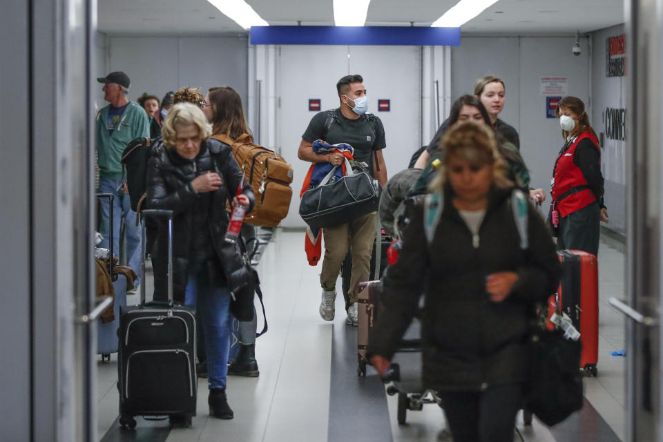 Travelers arrive at the international terminal of the O'Hare Airport in Chicago, Illinois, on March 15, 2020. - Chaos gripped major US airports Sunday as Americans returning from coronavirus-hit European countries overwhelmed authorities attempting to process the surge.Frustrated passengers complained of hours-long lines, crowded and unsanitary conditions and general disarray in the system for screening people for symptoms of the virus.Chaos gripped major US airports Sunday as Americans returning from coronavirus-hit European countries overwhelmed authorities attempting to process the surge. Frustrated passengers complained of hours-long lines, crowded and unsanitary conditions and general disarray in the system for screening people for symptoms of the virus. Schools, museums, sports arenas and entertainment venues have closed in some states, but St. Patrick's Day celebrations still filled bars and restaurants over the weekend, leading some local officials to consider more extensive shutdowns. (Photo by KAMIL KRZACZYNSKI / AFP) (Photo by KAMIL KRZACZYNSKI/AFP via Getty Images)