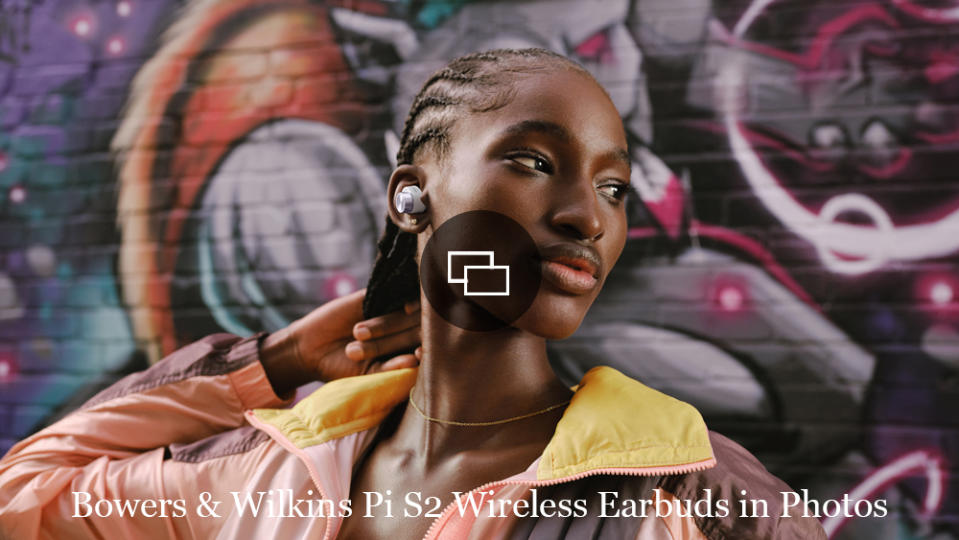 A young woman wearing Bowers & Wilkins Pi5 S2 wireless earbuds.