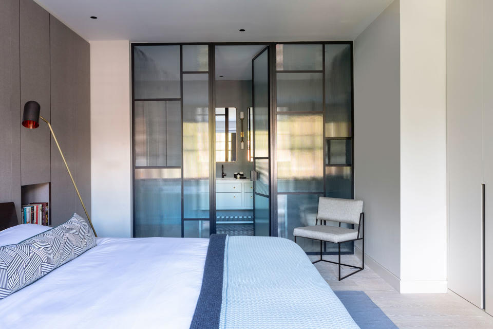 A bedroom with ensuite divided with glass critall doors