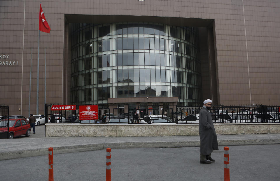 A man walks past the entrance to Istanbul's court Wednesday, Feb. 24, 2021, where the case of a Turkish private airline official and two pilots over their involvement in former Nissan Motor Co. chairman Carlos Ghosn's dramatic escape out of Japan in 2019 and to Beirut, Lebanon, was held. The court convicted a Turkish private airline official and two pilots and sentenced them each to four years and two months in prison .Ghosn, who was arrested over financial misconduct allegations in Tokyo in 2018, skipped bail while awaiting trial there. (AP Photo/Mehmet Guzel)