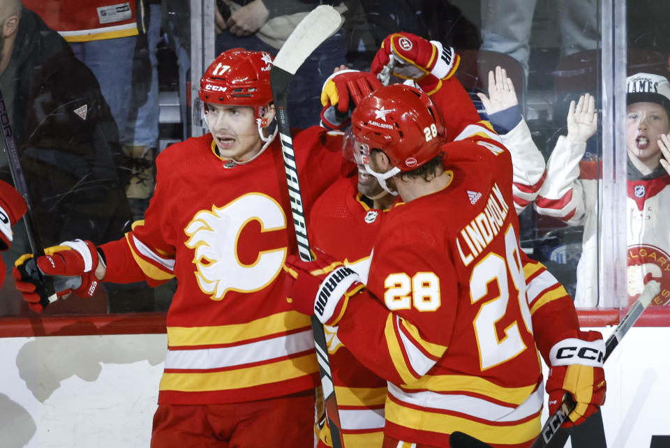 Calgary Flames forward Yegor Sharangovich (17) celebrates his overtime goal with teammates after an NHL hockey game against the Arizona Coyotes, Tuesday, Jan. 16, 2024 in Calgary, Alberta. (Jeff McIntosh/The Canadian Press via AP)