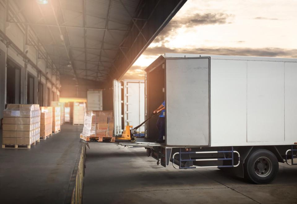 A truck backing up into a loading dock.