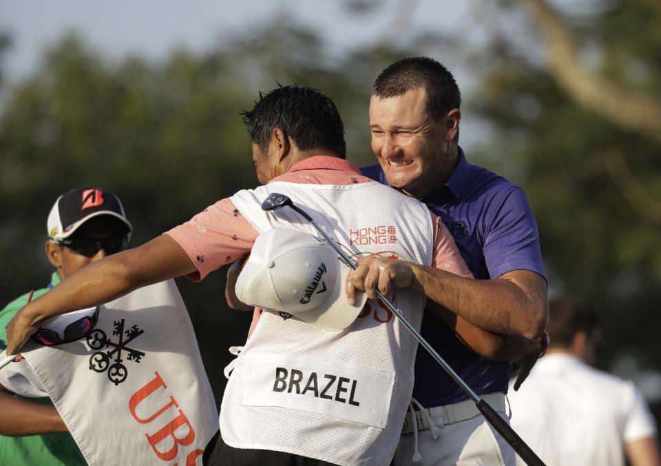 Australia's Sam Brazel, right, celebrates with his caddie on the 18th hole after winning the Hong Kong Open golf tournament in Hong Kong, Sunday, Dec. 11, 2016. Brazel birdied the 18th hole to narrowly edge Rafa Cabrera Bello of Spain to capture the Hong Kong Open on Sunday, his first title on the European Tour. (AP Photo/Kin Cheung)