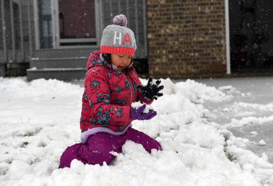 Sophia Zhao, 5, plays in the snow after school was canceled for the impending storm on Friday, December 10, 2021, in Sioux Falls.