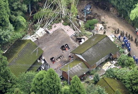 An aerial view shows rescue workers searching for a missing resident at a collapsed house due to a landslide caused by heavy rain in Soo, Kagoshima prefecture, Japan