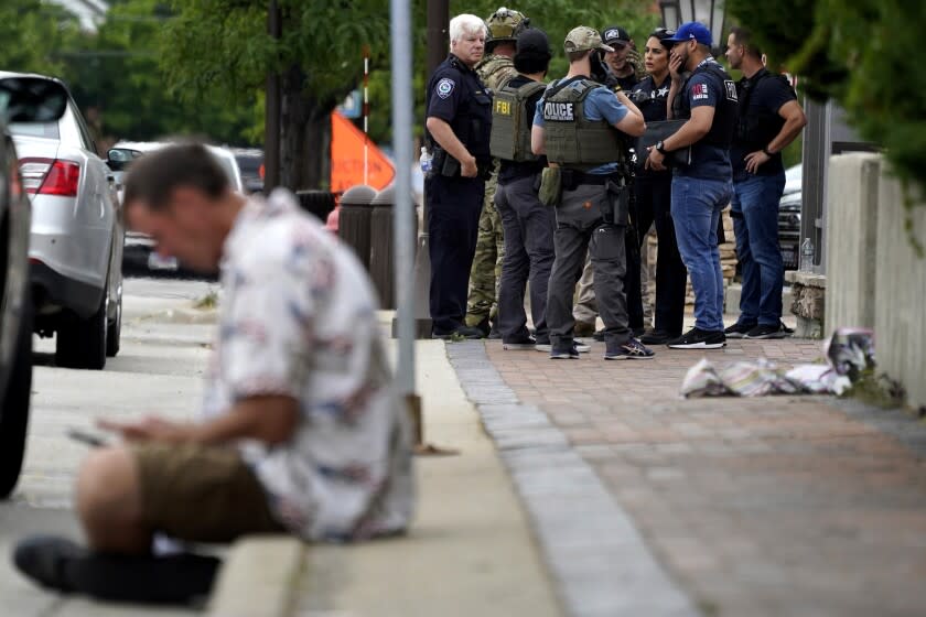 Law enforcement search after a mass shooting at the Highland Park Fourth of July parade in downtown Highland Park, a Chicago suburb on Monday, July 4, 2022. (AP Photo/Nam Y. Huh)