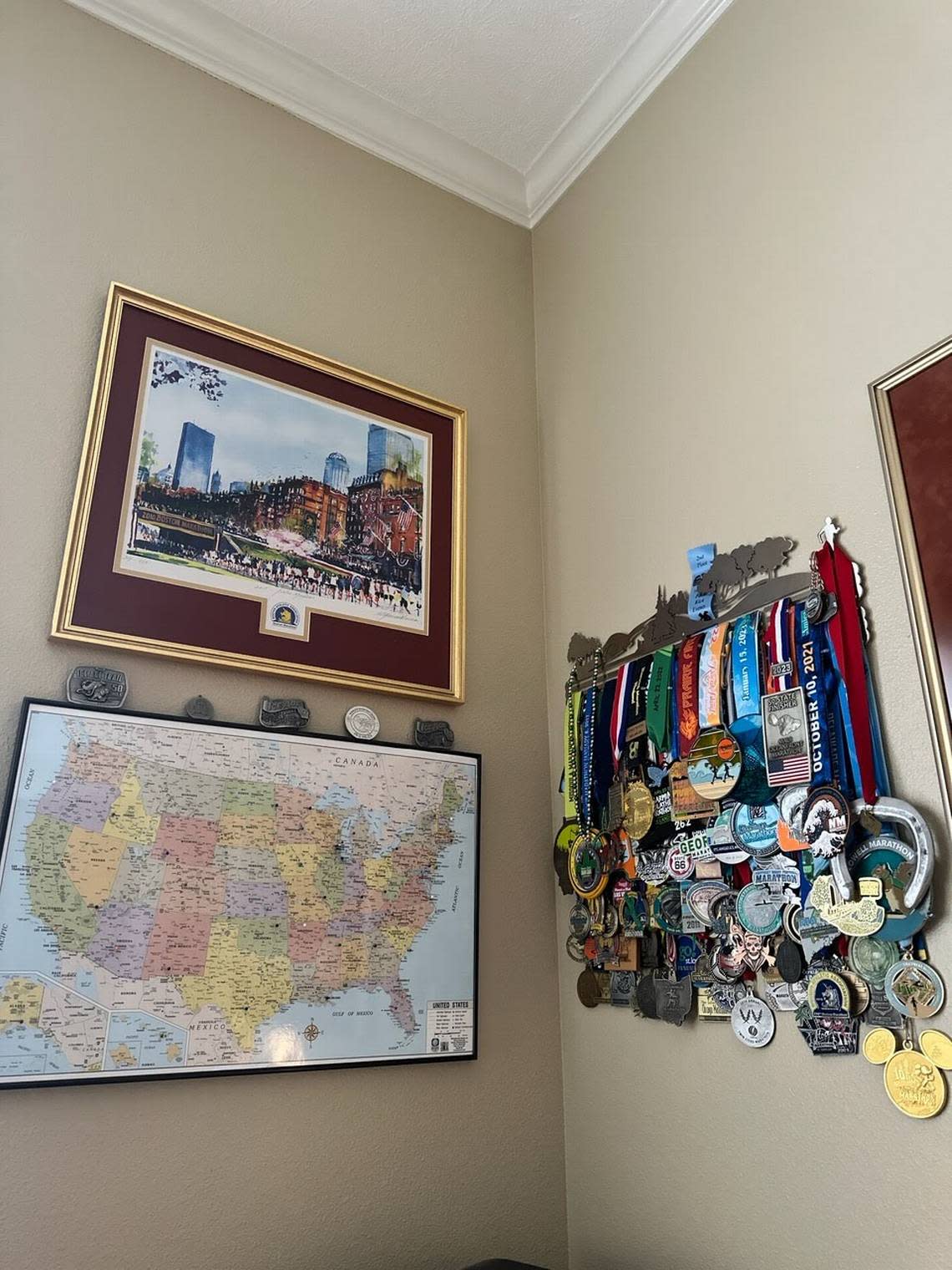 Bob Mueller keeps mementos from his marathons at his Garden City home: medals from numerous races, a photo of his Boston Marathon finish and a map marked with the locations where he ran marathons in each state.